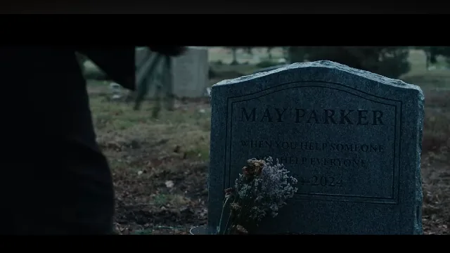 Tumba de May Parker con flores en un cementerio